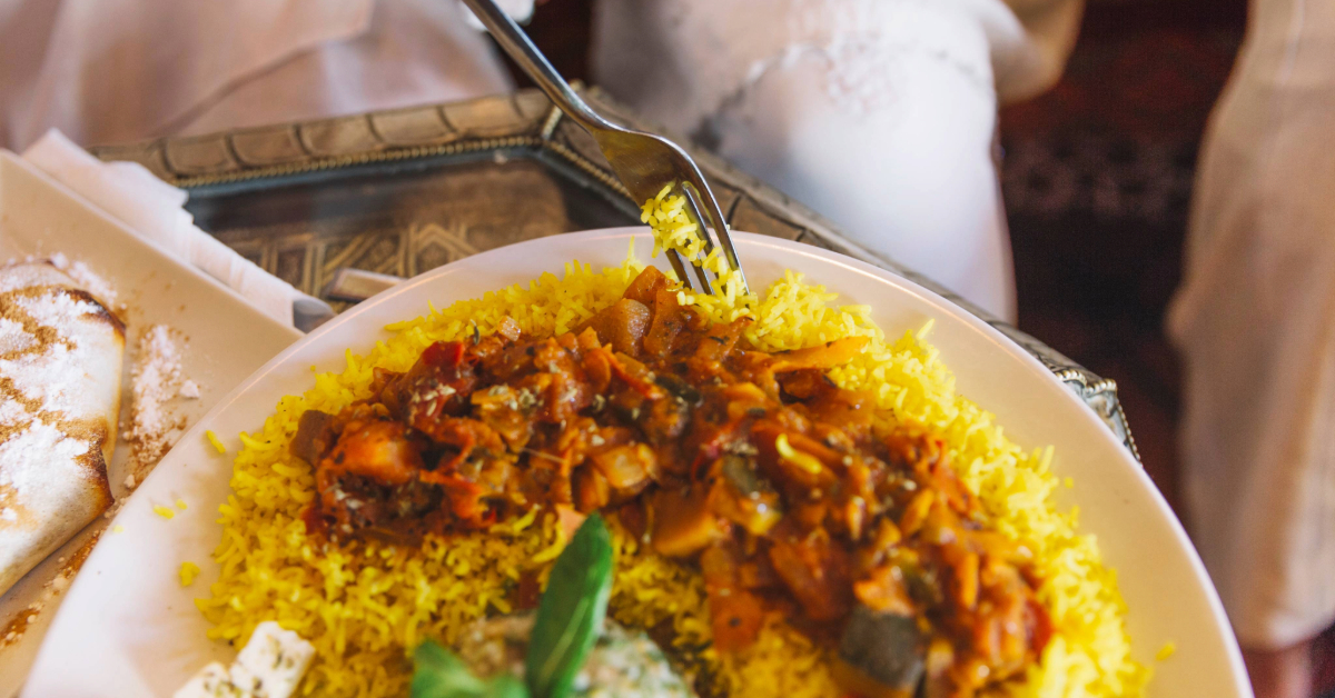 A person eating the best biriyani in a Sharjah restaurant