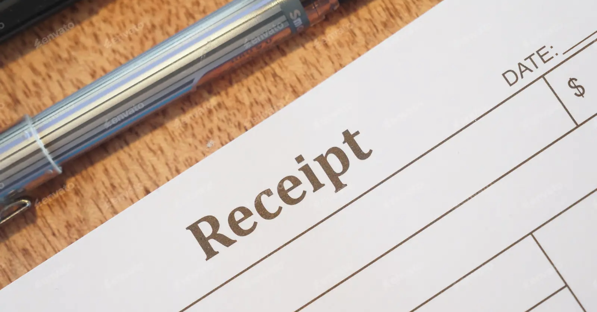 A receipt and a pen on a wooden table