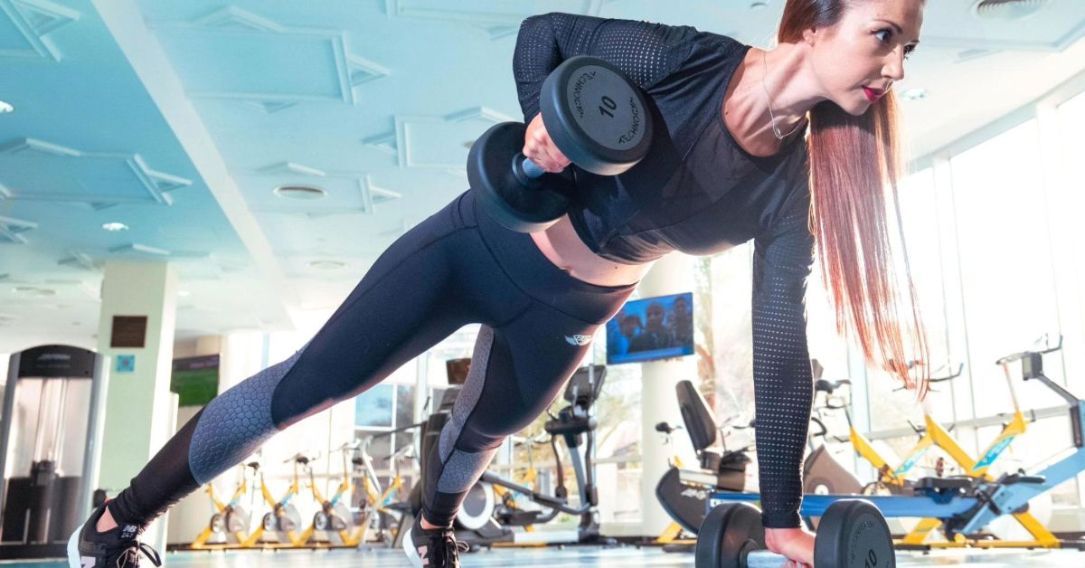 A woman holding dumbbells and working out in a gym