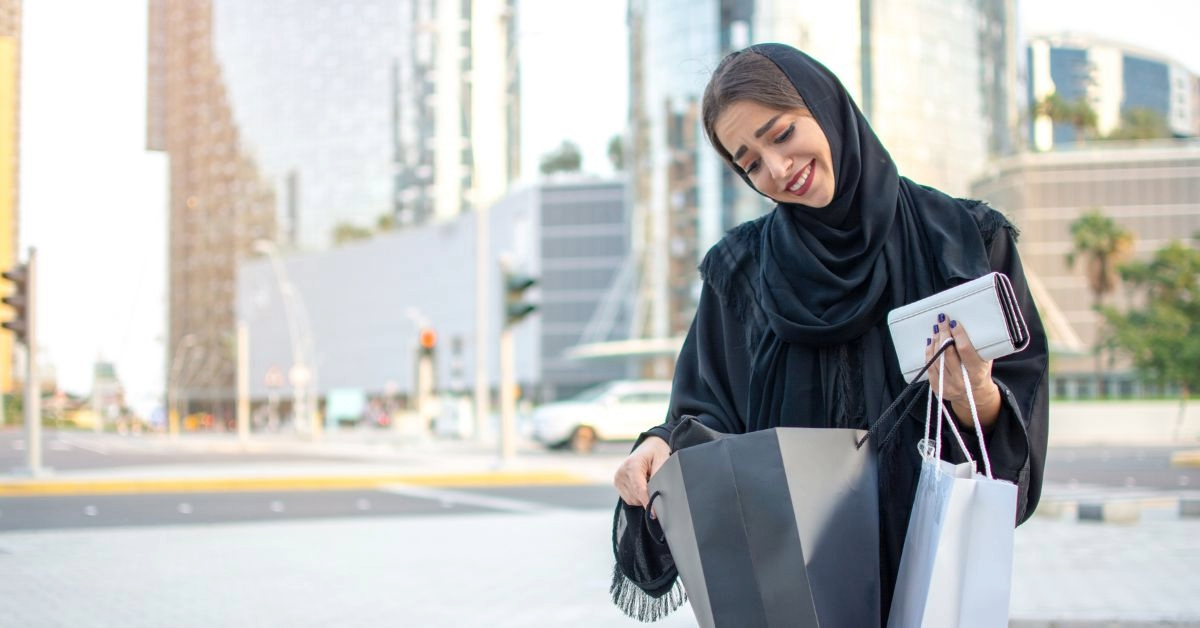 A woman holding shopping bags and a wallet