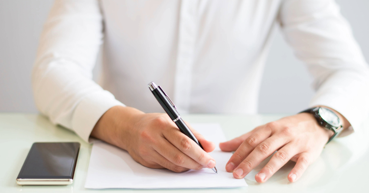 Closeup of man working and writing on sheet of paper