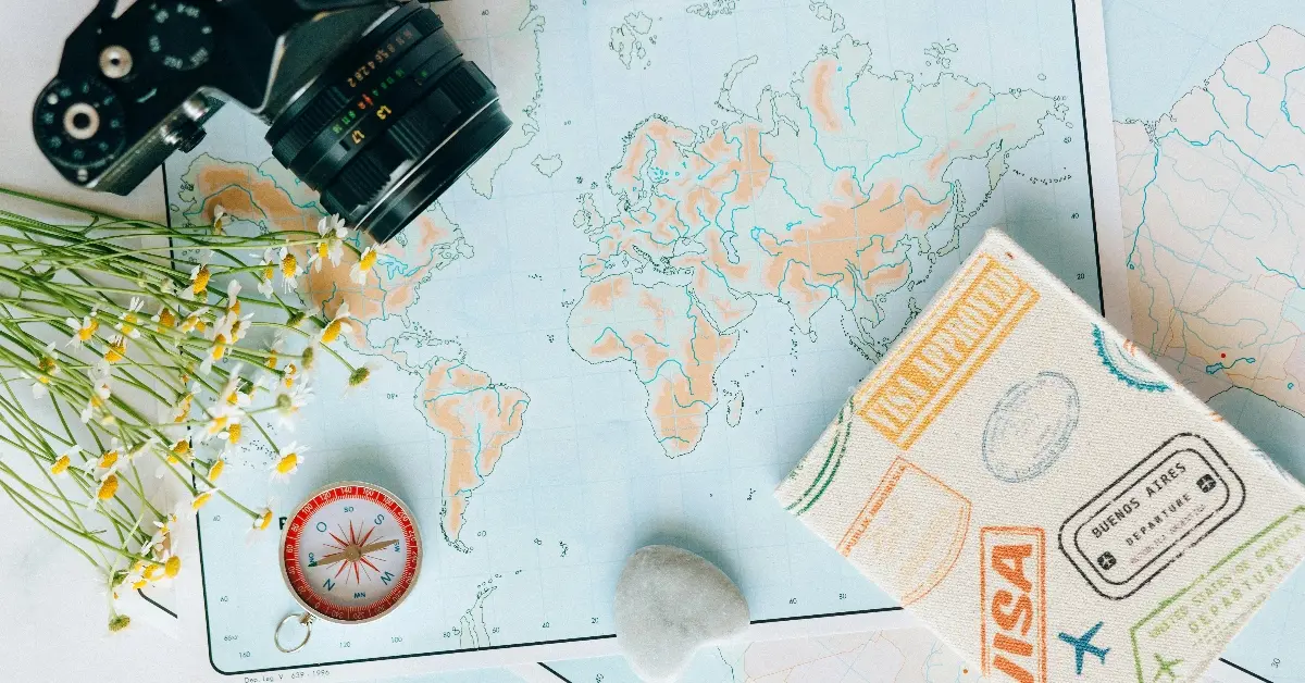  A visa, a camera, a compass, and a rock lying on the table of maps