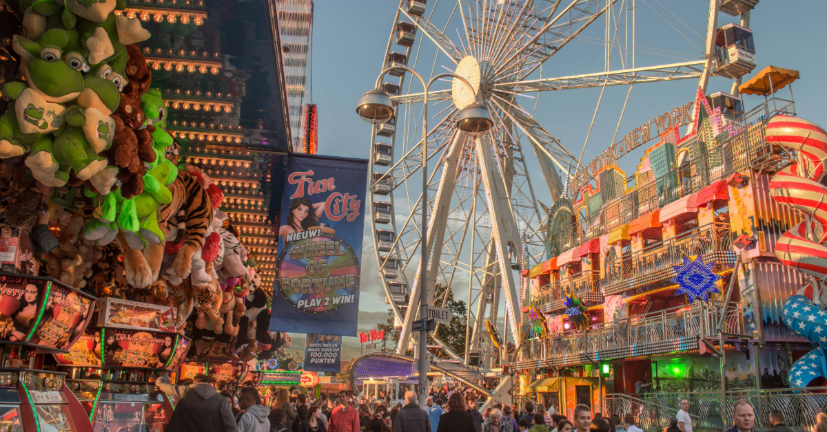 A crowded amusement park with a giant Ferris wheel