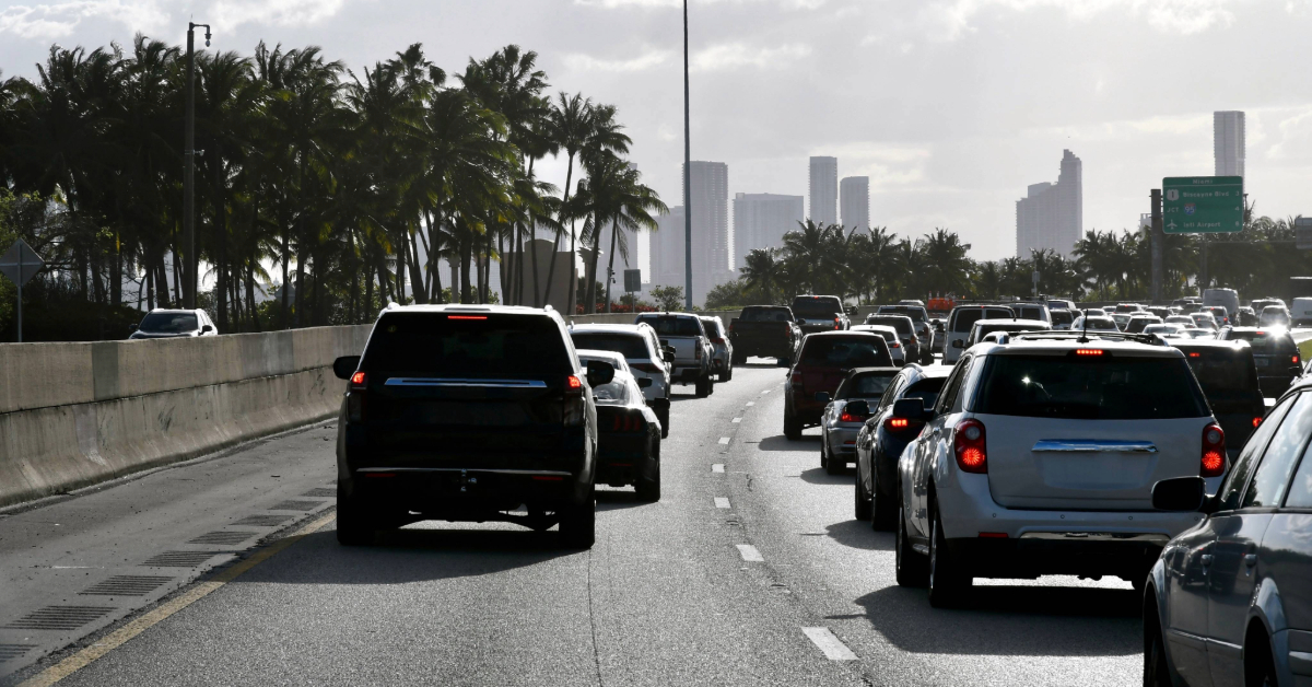 Highway traffic with buildings and palm trees