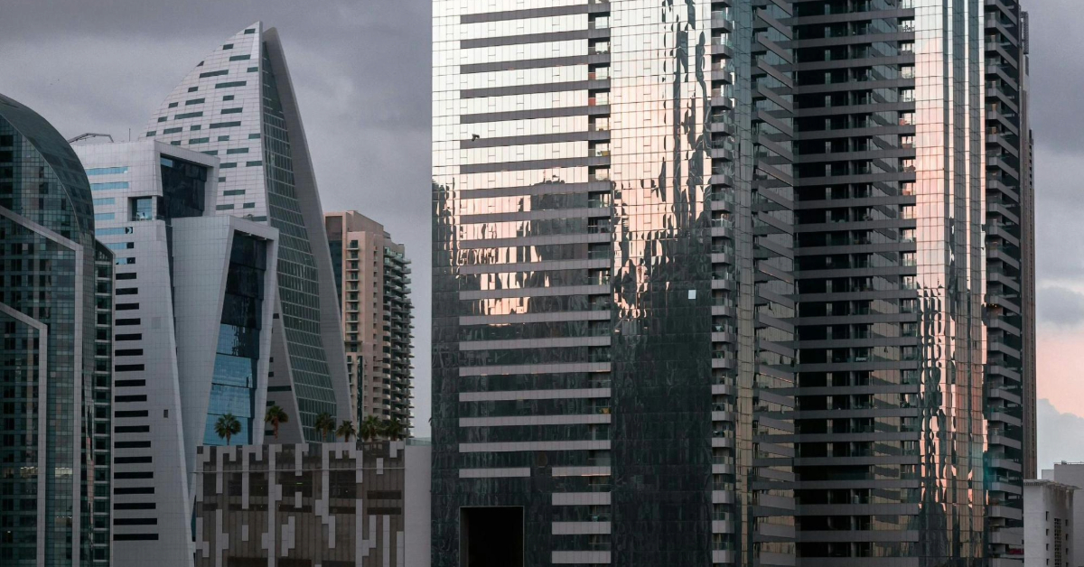The sunset reflecting off the glass of the JBR towers near the court