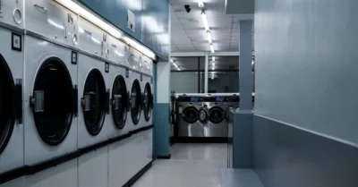 A row of white washing machines in a laundry room