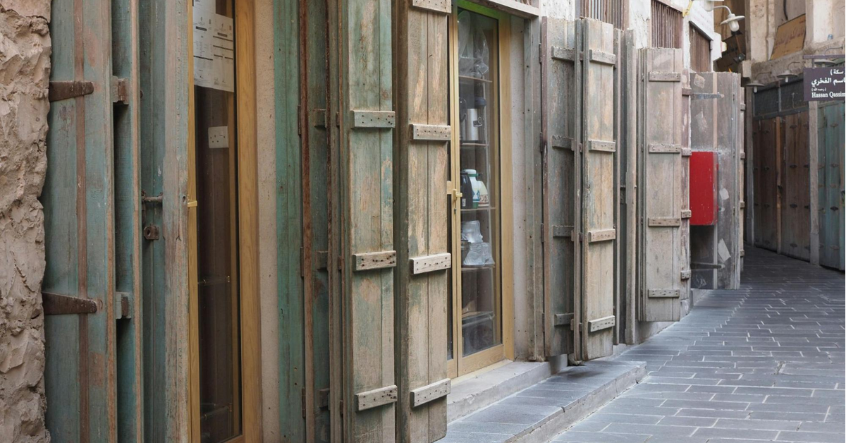 Exterior entrance to Souk Al Arsah featuring traditional wooden gates and signage