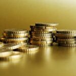 Stacks of golden coins on a golden background.