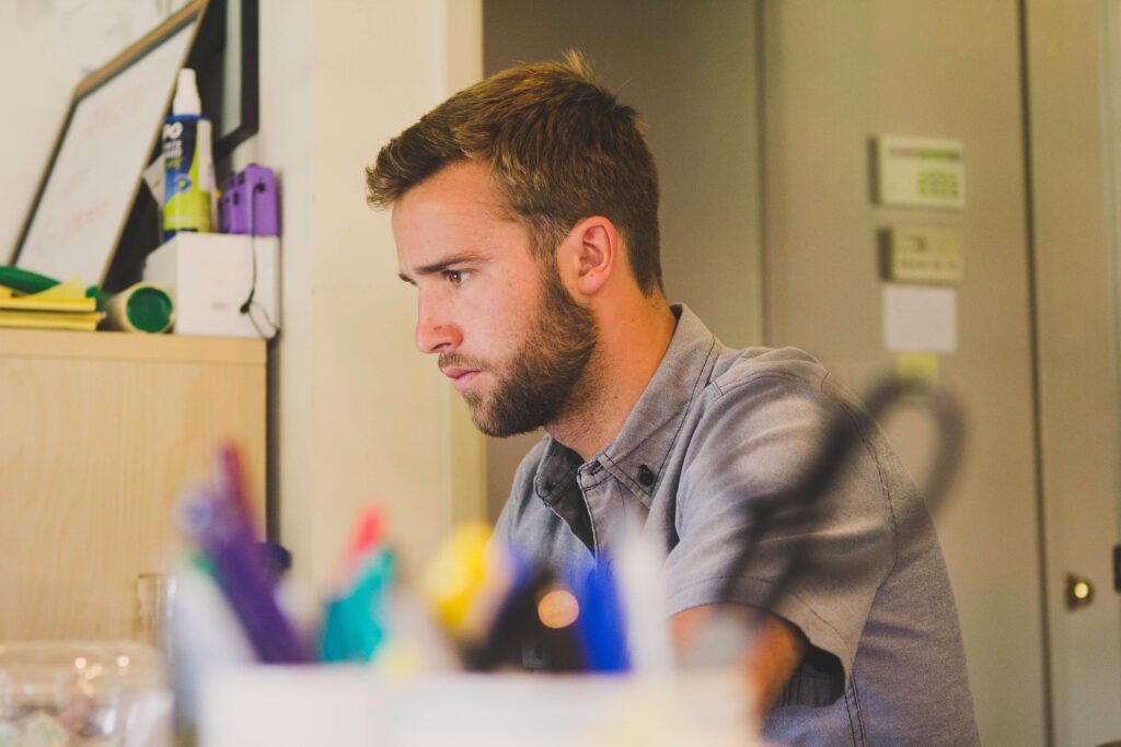 Young male real-estate entrepreneur concentrating at his desk, illustrating the focus needed for new agencies to overcome Dubai’s “visibility gap.”