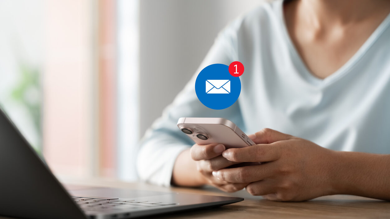 Real estate professional checking email follow-up notification on smartphone, emphasizing timely client communication and digital follow-through.