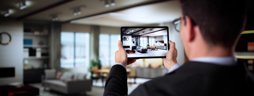 Real estate agent filming a property video tour with a tablet to showcase a modern living room for online listings.