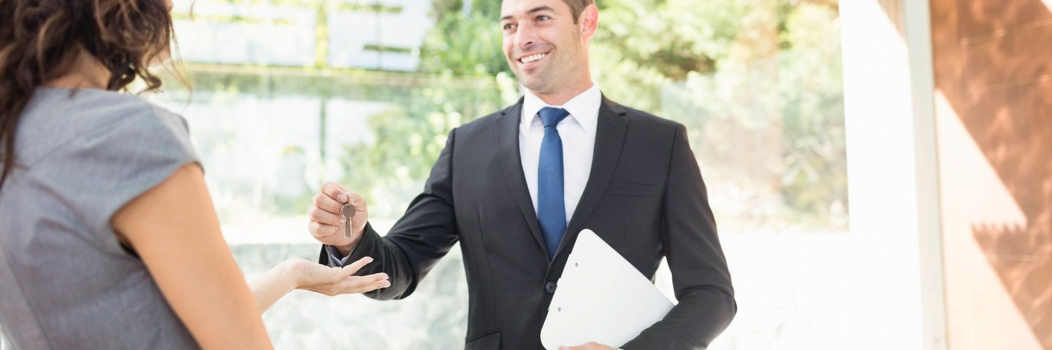 Real estate agent handing over keys to investor client during Dubai off-plan property handover process.