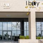 Exterior of I Buy Real Estate office in Dubai alongside portrait of Alan Harthy, Founder & CEO, at the Aldar Honours Awards.