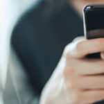 Close-up of hands using a smartphone for WhatsApp messaging—UAE real estate agents running compliant broadcasts with segmentation, approved templates, and CRM logging to boost lead conversion.