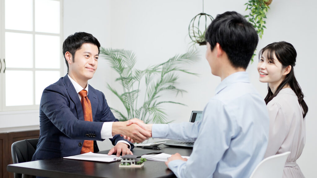 Real estate agent meeting with prospective clients in Dubai, shaking hands at the end of a successful lead qualification conversation — illustrating trust, consent-based outreach, and UAE property market engagement.