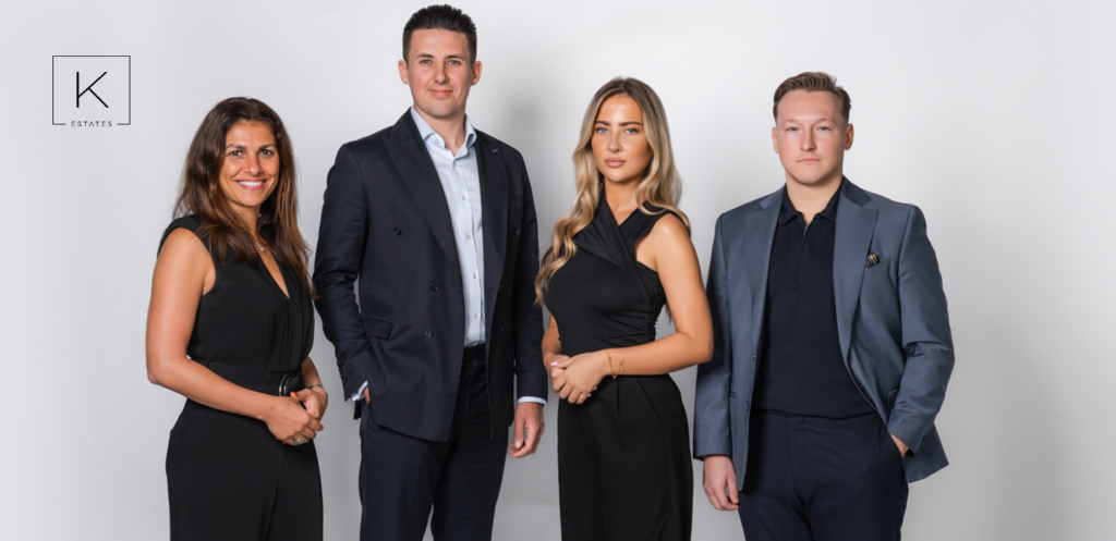 K Estates Dubai real estate team standing together in formal business attire, showcasing the trusted agents who build client confidence in off-plan property investment.