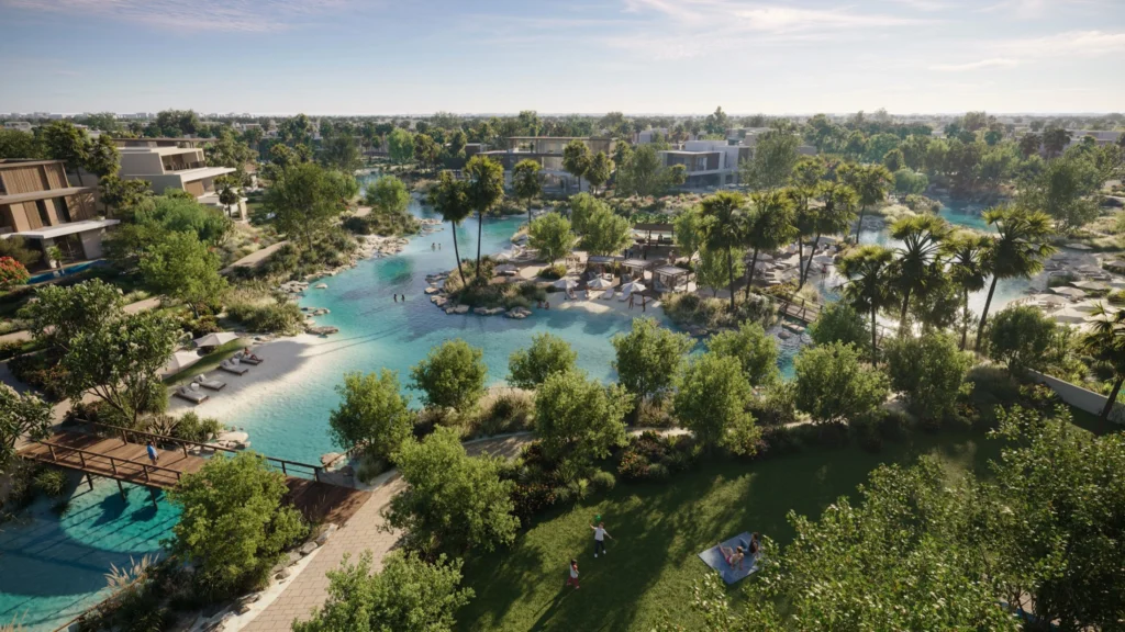 Aerial view of a next-generation Dubai master-planned community with turquoise lagoons, wooden bridges, sandy edges and lush greenery surrounded by modern low-rise villas, illustrating the future direction of resort-style residential living.