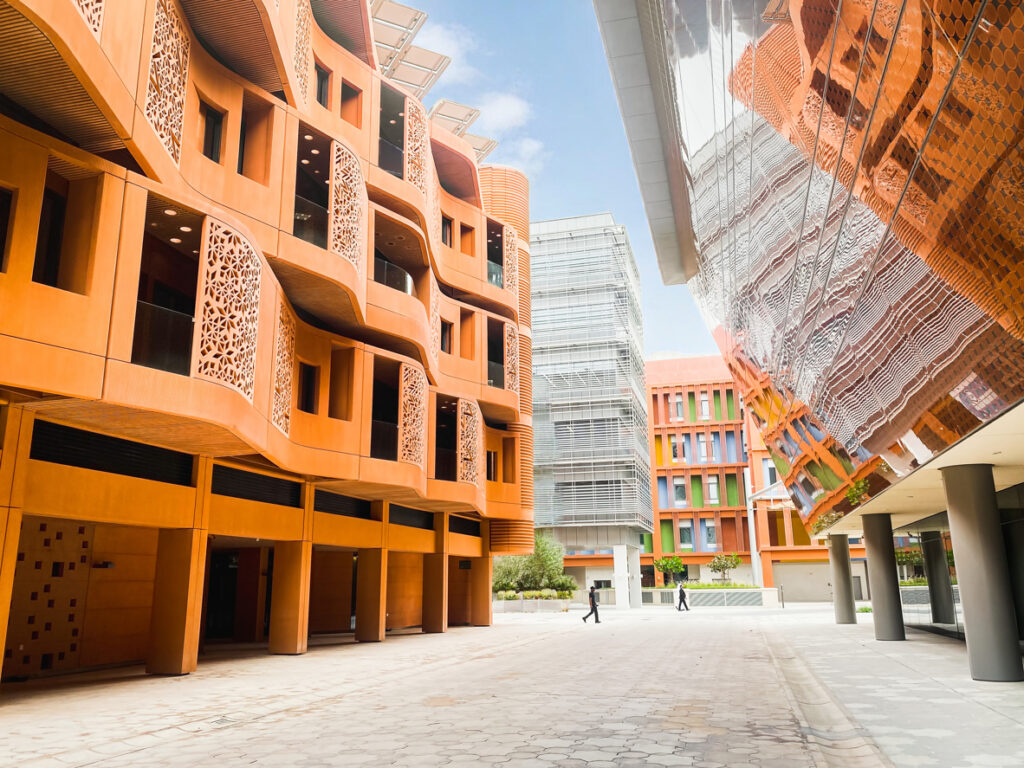 Masdar City in Abu Dhabi featuring sustainable residential and mixed-use buildings with energy-efficient façades, shaded walkways, and eco-friendly urban design, showcasing green architecture in the UAE.