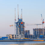 Off-plan real estate construction in Dubai with multiple residential towers under development, illustrating the regulated off-plan property sales process for agents and investors