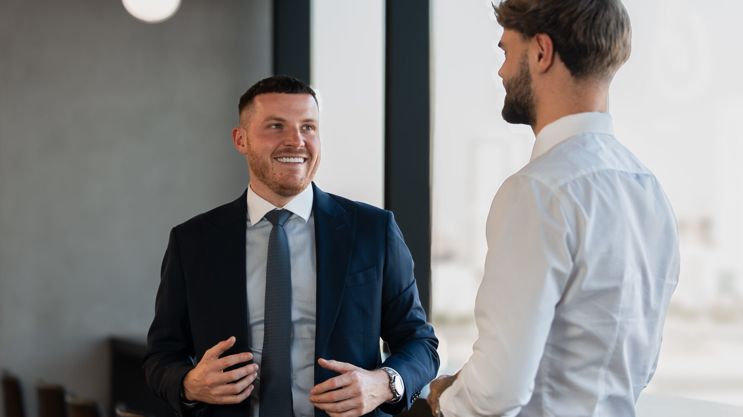 Senior real estate manager coaching a broker one-on-one in a Dubai office, discussing expectations, performance goals, and personalised sales development strategies.