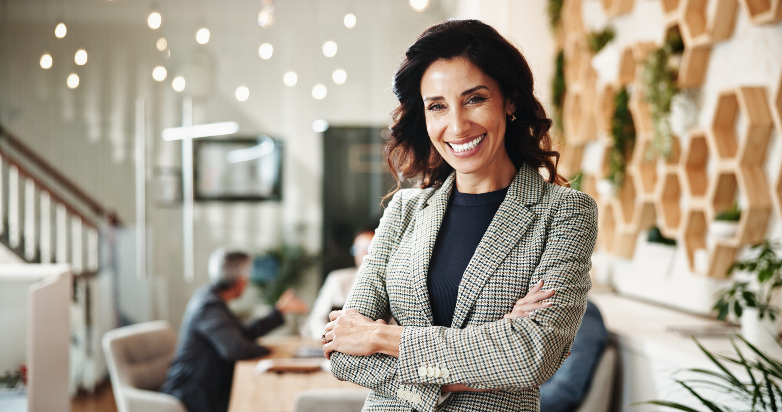 Confident Dubai real estate agency owner smiling in a modern office, representing authentic leadership styles and broker team culture in the UAE.