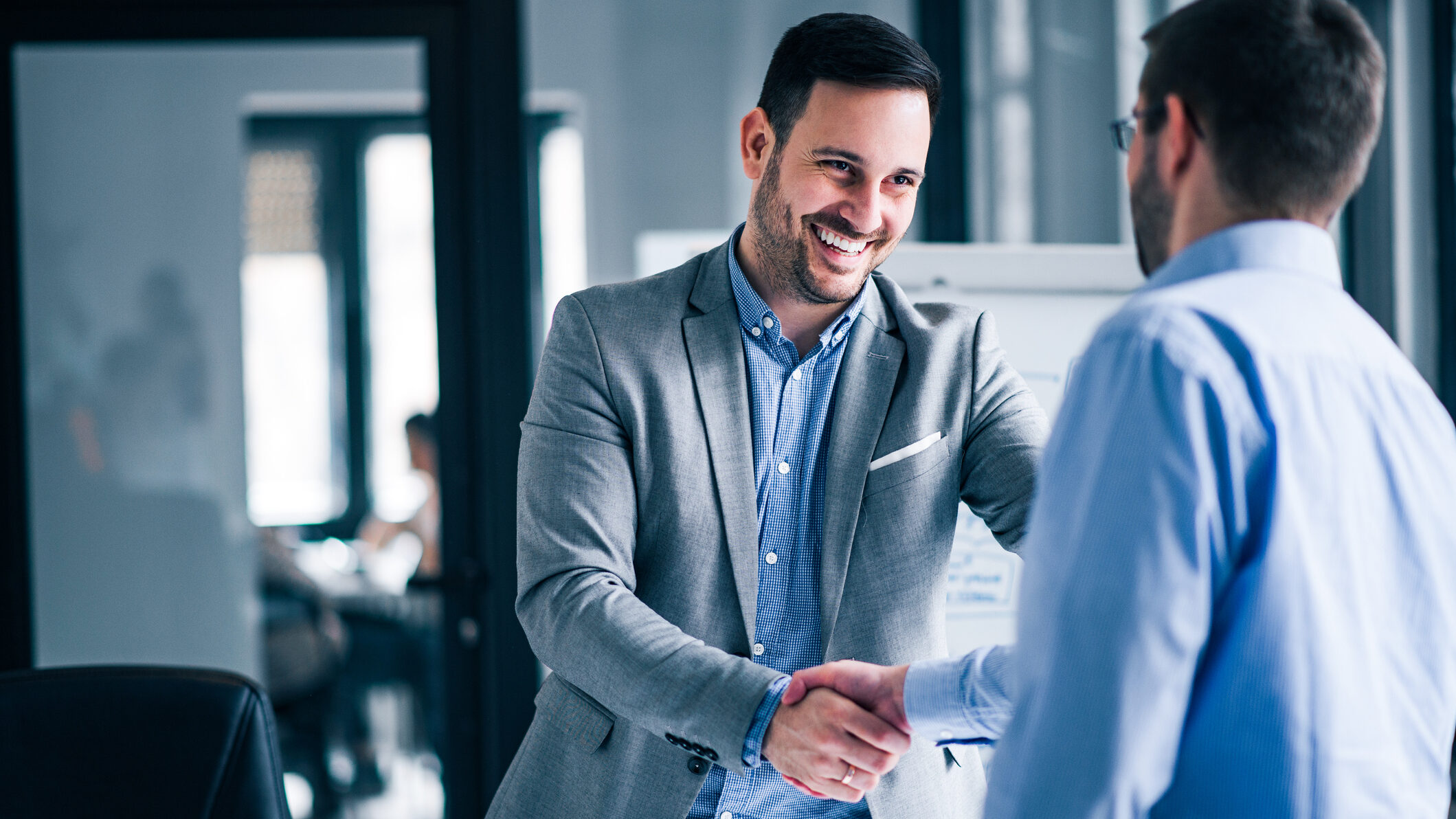 Dubai real estate agent shaking hands with a client during a property consultation in a modern office in the UAE