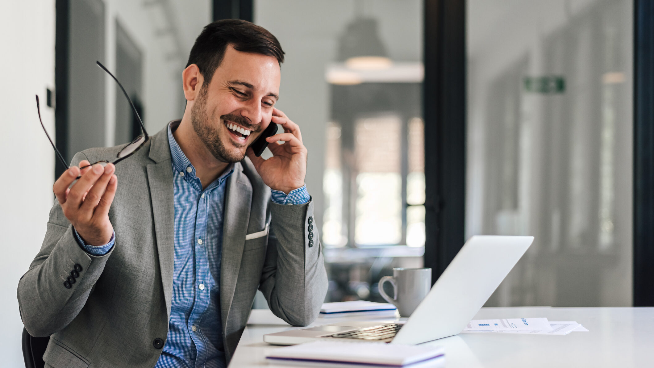 Dubai real estate agent enjoying success after designing a repeatable weekly plan, using a laptop to manage leads, follow-ups, and client communication in the UAE